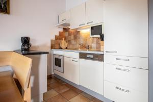 a kitchen with white cabinets and a sink at Chalet Central Top CC 7 in Königsleiten