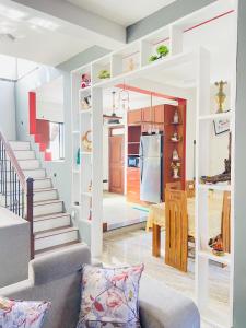 a living room and kitchen with white walls and stairs at Erin Orr Villa in Wadduwa