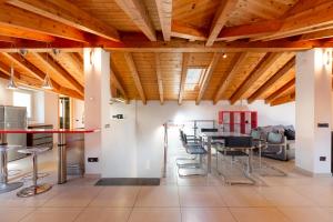 a room with wooden ceilings and tables and chairs at Luxury Villa Laglio in Laglio