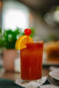 a drink with a cherry on top on a table at Coconut Court Beach Hotel in Bridgetown