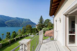 a balcony with a view of a lake and mountains at Luxury Villa Laglio in Laglio