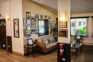 a living room with a couch and pictures on the wall at Coconut Court Beach Hotel in Bridgetown