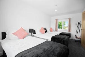 a bedroom with two beds and a window at Family Contractors 3 bed house free parking sleeps7 in Bilston
