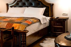 a bedroom with a bed with a wooden headboard and a table at Boutique Marlen in Ghimbav +111 photos