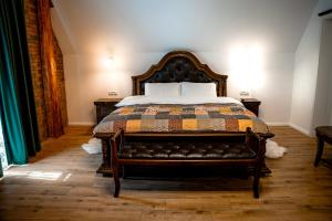 a bedroom with a bed with a leather couch at Boutique Marlen in Ghimbav