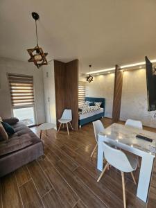 Apartman Zagorac في ديفشيبار: غرفة معيشة مع أريكة وطاولة وكراسي