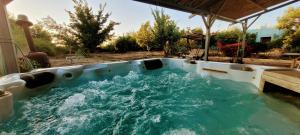 a hot tub with water in it in a backyard at בקתת המפל הלבן in Eli Ad