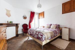 Un dormitorio con una cama con una cortina roja. en Appartement authentique à colombage 15mn de Disney, en Ferrières-en-Brie