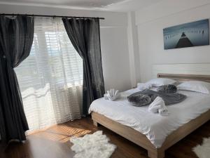 a bedroom with a bed with towels and a window at Green Apartaments Self Check-In 24-7 Free Parking in Zărneşti