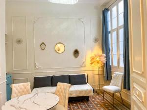 a living room with a couch and a table at Apartamentos Loles De Cisneros Catedral in Málaga