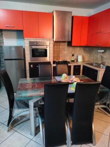 a kitchen with red cabinets and a glass table and chairs at Casa Luciana in Santa Maria del Molise +8 photos