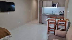 a kitchen with a table and two stools in a room at Velvet Apart in Esperanza +13 photos