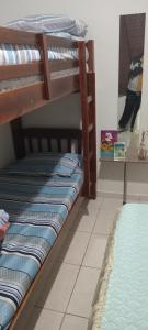 a room with two bunk beds in a room at Edifício Cannes AP 16A in Praia Grande