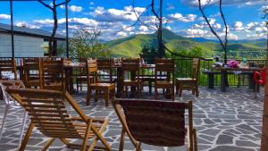 a patio with chairs and tables and mountains in the background at Bolnisi Elia in Bolnisi