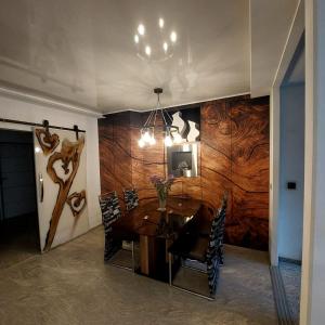 a dining room with a wooden wall with a table and chairs at Private Apartment Laatzen City in Hannover