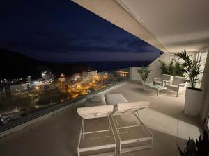a balcony with a view of a city at night at Grand Horizon Luxury Boutique Apartments in Puerto Rico de Gran Canaria