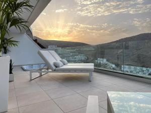a white couch sitting on a balcony with a view at Grand Horizon Luxury Boutique Apartments in Puerto Rico de Gran Canaria