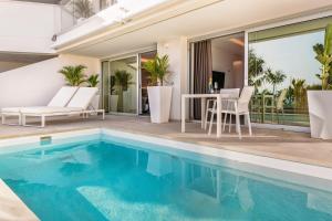 a house with a swimming pool and a patio at Grand Horizon Luxury Boutique Apartments in Puerto Rico de Gran Canaria