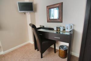 a desk with a mirror and a chair in a room at Best Western Plus Oaklands Hotel in Norwich