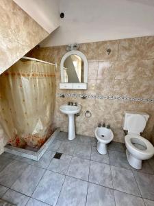 ein Badezimmer mit Waschbecken, Toilette und Spiegel in der Unterkunft La Soñada in Alta Gracia