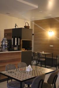 a dining room with tables and chairs and a kitchen at Horizons Hotel Rooms in Batumi