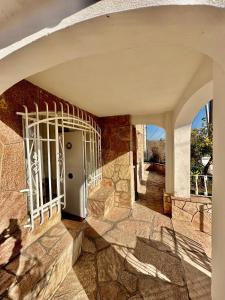 ein Eingang zu einem Steingebäude mit einem weißen Tor in der Unterkunft La Soñada in Alta Gracia