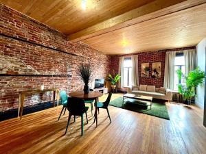 a living room with a brick wall and a table and chairs at Le 224 - Appartements Pura Vida in Quebec City +22 photos