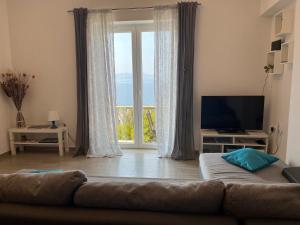 a living room with a couch and a large window at Apartments Mediterano in Senj