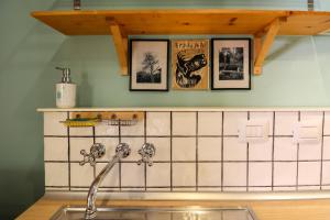 a kitchen with a sink and pictures on the wall at Appartamento Capodilucca in Bologna +19 photos