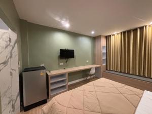 a room with a bed and a tv on a wall at เดอเนส บูติก โฮมสเตย์ C9 Denest Boutique Homestay in Ban Phai +10 photos