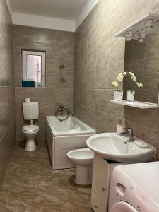 a bathroom with a sink and a toilet and a tub at Apartments Mediterano in Senj +37 photos