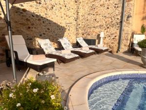 une terrasse avec des chaises longues et une piscine dans l'établissement La Rose des Vins, à Pouzolles