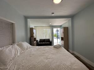 怀尔德伍德Hotel on Magnolia East 'HOME'的卧室里有一张白色的大床和一把椅子