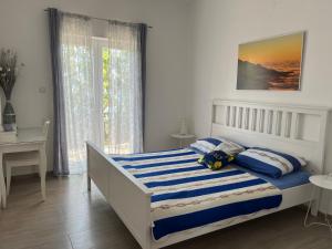 a bedroom with a bed with blue and white sheets at Apartments Mediterano in Senj