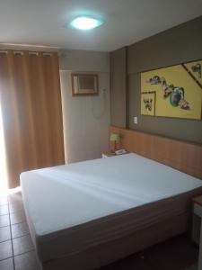 a bedroom with a large white bed in a room at Splendor Thermas in Caldas Novas