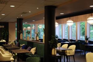 a restaurant with tables and chairs and windows at Vänerport Stadshotell i Mariestad in Mariestad