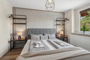 a bedroom with a large bed with two lamps at Harzduft - Wanderbasis mit Bergblick & Garten in Thale