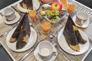 a table with plates of food and a tray of fruit at Harzduft - Wanderbasis mit Bergblick & Garten in Thale