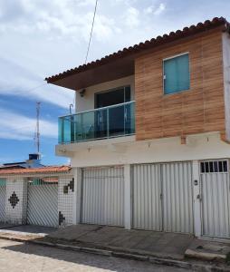 a house with a balcony on top of it at Casa 3quartos rota Maragogi Carneiros in São José da Coroa Grande