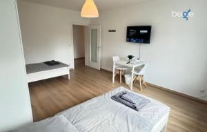 a room with a bed and a table and a tv at BEGE APARTMENTS Corporate Hub in Lüdenscheid