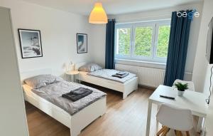 a bedroom with two beds and a table and a desk at BEGE APARTMENTS Corporate Hub in Lüdenscheid