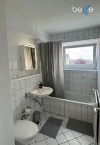 a bathroom with a sink and a tub and a toilet at BEGE APARTMENTS Corporate Hub in Lüdenscheid