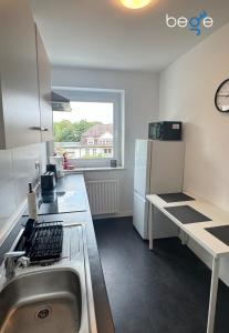 a small kitchen with a sink and a refrigerator at BEGE APARTMENTS Corporate Hub in Lüdenscheid