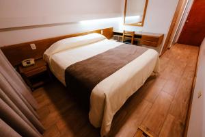 a bedroom with a large bed and a wooden floor at HOTEL ARENALES in San Fernando del Valle de Catamarca +12 photos
