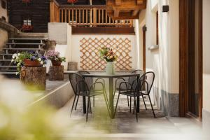 a table and chairs on a patio with flowers at Bonvivar - Mountain Guesthouse in Livigno