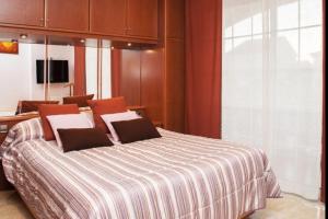 a bedroom with a large bed with a striped blanket at Telemann - Xeckin Holidays in El Vendrell +32 photos
