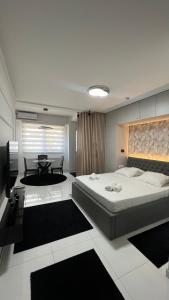 a bedroom with a large bed and a table at A'dors Apartments in Skopje