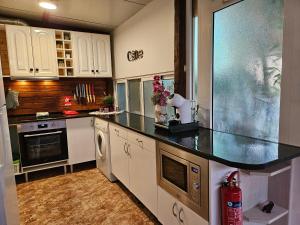 Una cocina con gabinetes blancos y una encimera negra. en La Manga Beach House, en La Manga del Mar Menor 15 fotos más