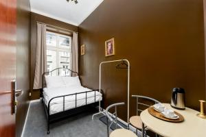クラクフにあるRPG Hostelのベッドとテーブルのある小さな部屋