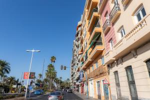 una calle de la ciudad con un edificio y un semáforo en L&G APARTMENTS BAHíA SUITE, en Alicante